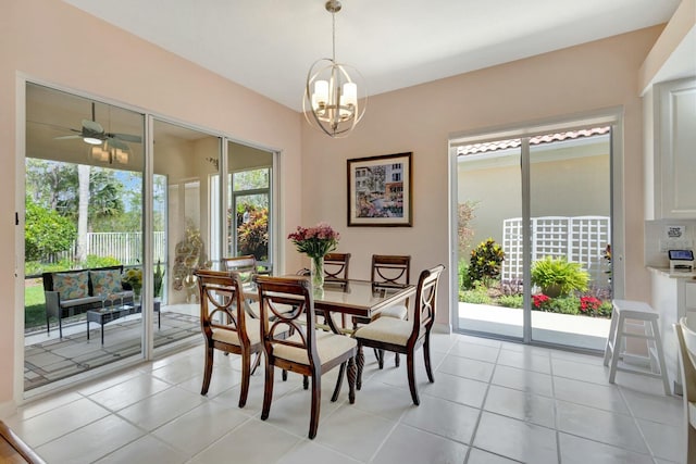 dining area with light tile patterned floors and ceiling fan with notable chandelier