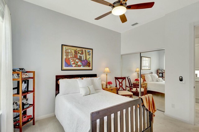 bedroom featuring light carpet, visible vents, baseboards, and a closet