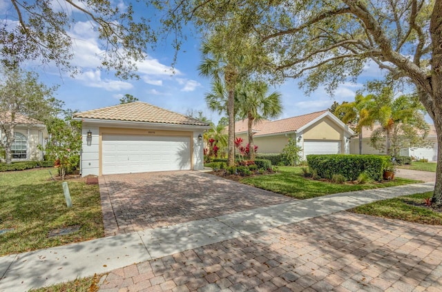 single story home with stucco siding, a front lawn, a tile roof, and a garage