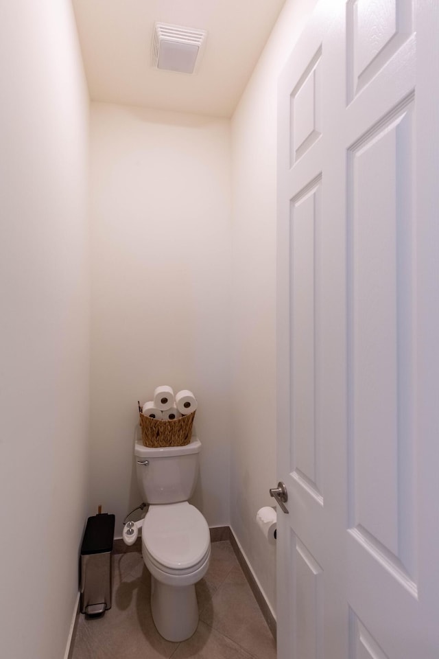 bathroom with toilet, tile patterned flooring, visible vents, and baseboards