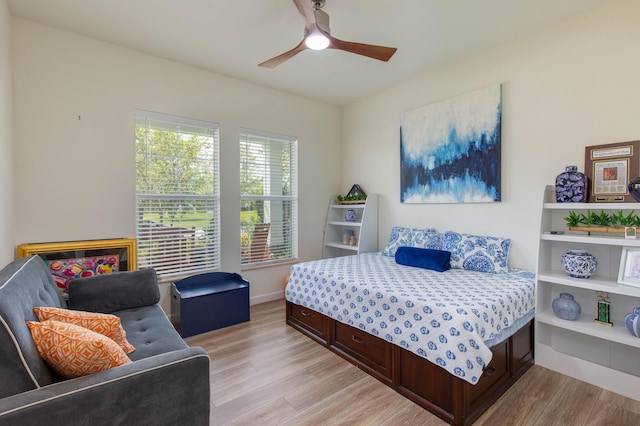 bedroom with a ceiling fan, light wood-type flooring, and baseboards