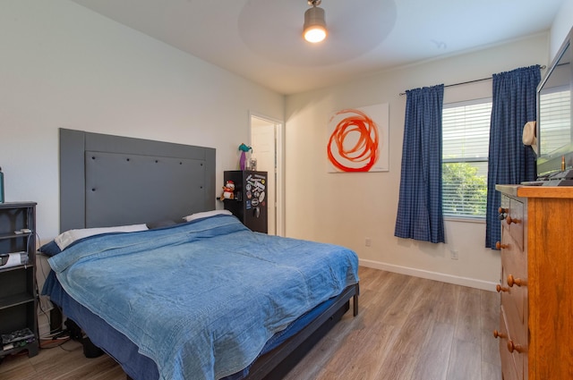 bedroom featuring a ceiling fan, baseboards, and wood finished floors