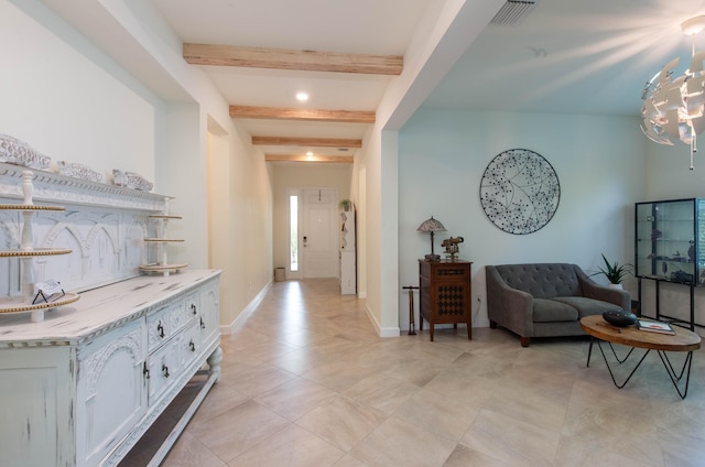 interior space with a chandelier, beamed ceiling, visible vents, and baseboards