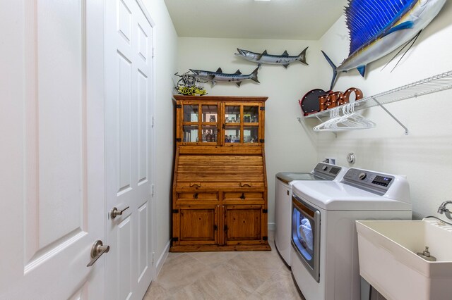 washroom with separate washer and dryer, laundry area, and a sink