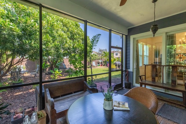 sunroom featuring ceiling fan and outdoor dining area