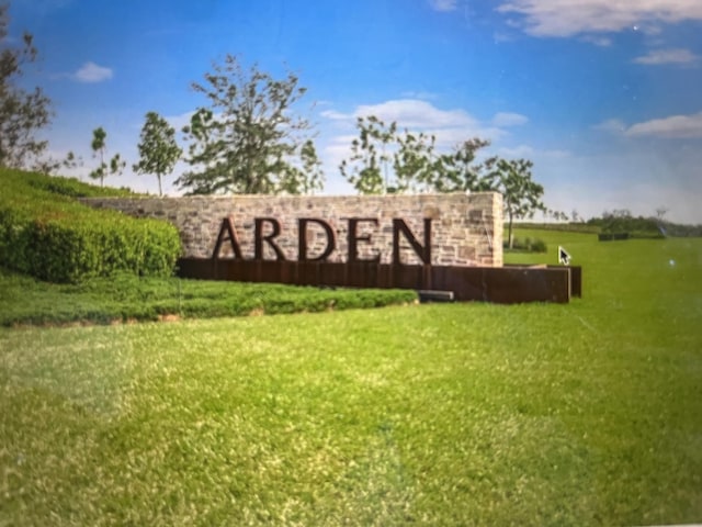 community / neighborhood sign featuring a lawn