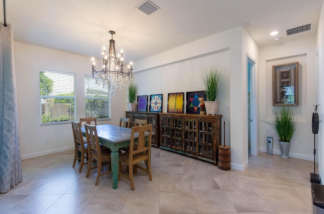 dining space with a notable chandelier, light tile patterned flooring, visible vents, and baseboards