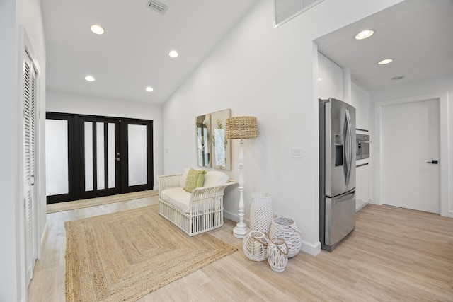 foyer with recessed lighting, visible vents, light wood-style flooring, and vaulted ceiling