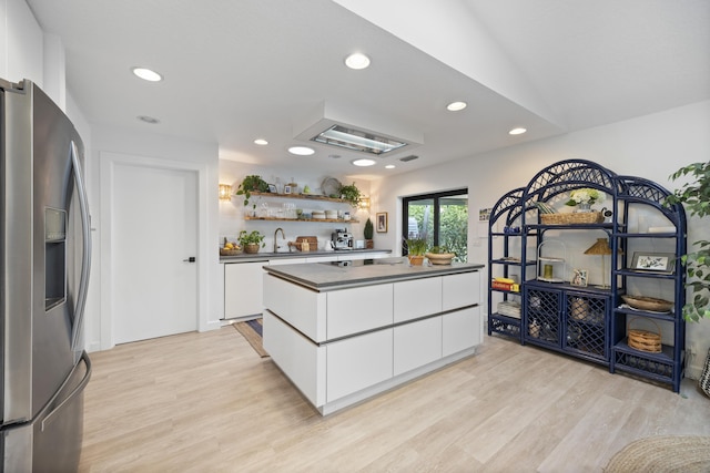 kitchen featuring white cabinetry, dark countertops, stainless steel refrigerator with ice dispenser, and light wood-type flooring