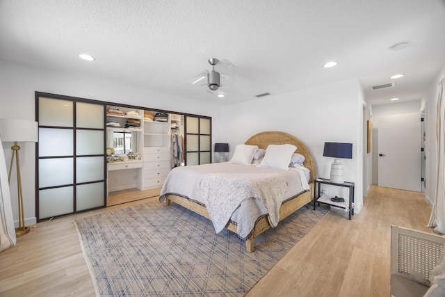 bedroom with light wood finished floors, visible vents, and recessed lighting