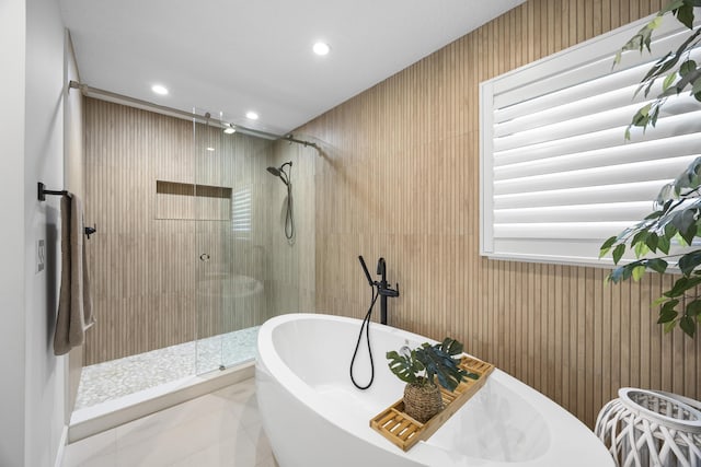 bathroom featuring tile patterned floors, recessed lighting, a stall shower, and a freestanding tub