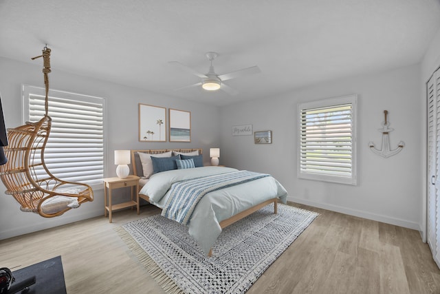 bedroom with baseboards, a ceiling fan, and light wood finished floors