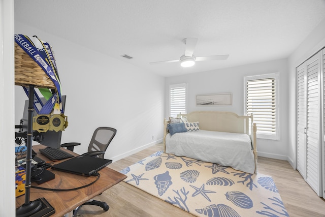 bedroom featuring light wood-style flooring, baseboards, and a closet