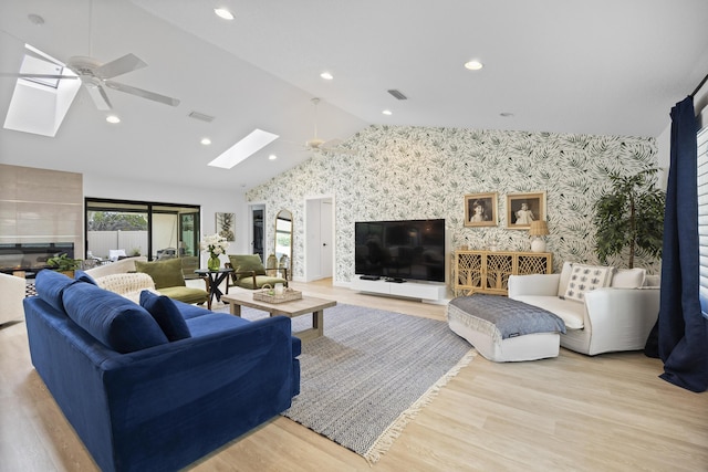 living room featuring visible vents, wallpapered walls, a ceiling fan, and wood finished floors