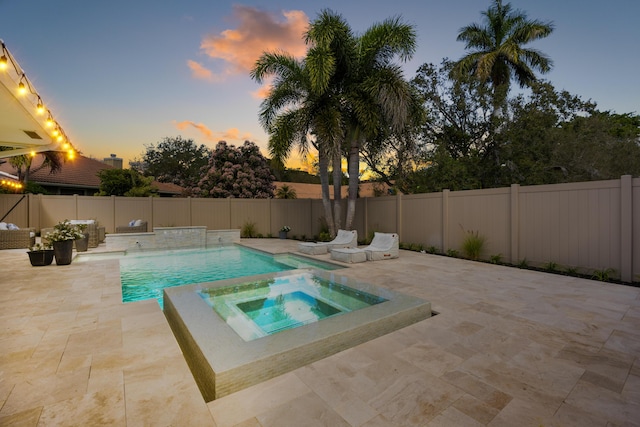 view of swimming pool featuring a patio area, a pool with connected hot tub, and a fenced backyard