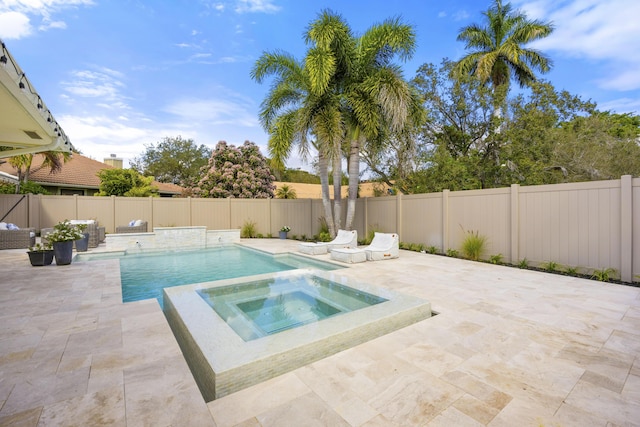 view of swimming pool featuring a pool with connected hot tub, a patio area, and a fenced backyard