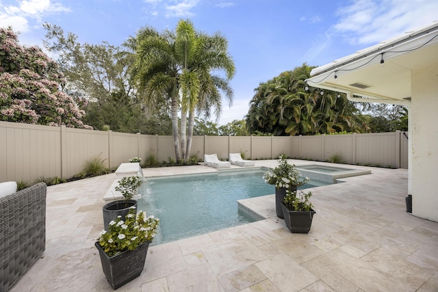 view of pool featuring a patio, a fenced backyard, and a pool with connected hot tub