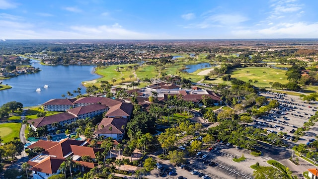 drone / aerial view with a residential view, view of golf course, and a water view