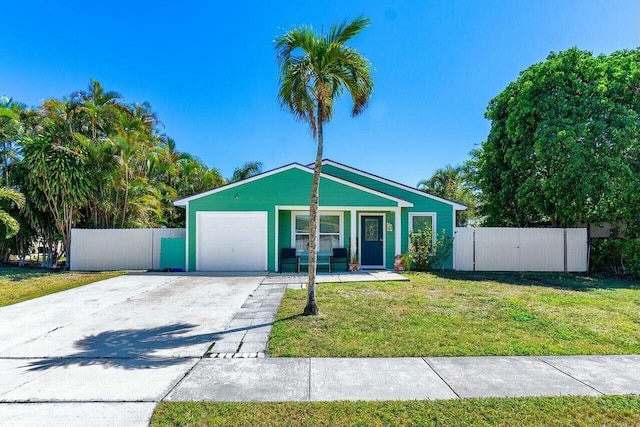 view of front of home featuring a front lawn, an attached garage, driveway, and fence