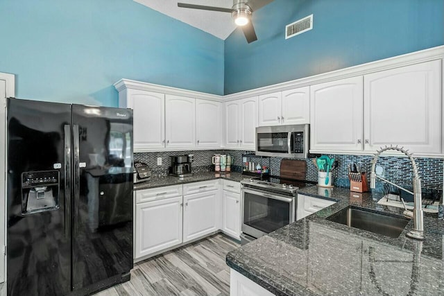 kitchen with visible vents, a sink, backsplash, white cabinetry, and stainless steel appliances