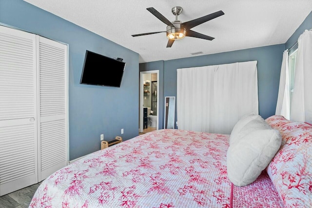 bedroom featuring visible vents, ensuite bath, ceiling fan, a closet, and a textured ceiling