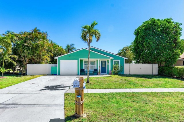 view of front of home with concrete driveway, a garage, fence, and a front yard