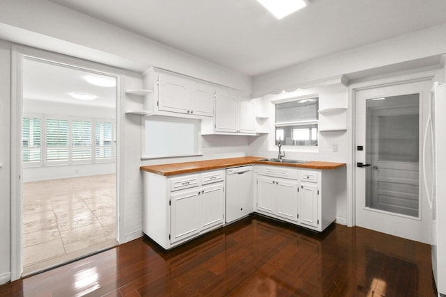 kitchen featuring open shelves, butcher block counters, white dishwasher, and a sink