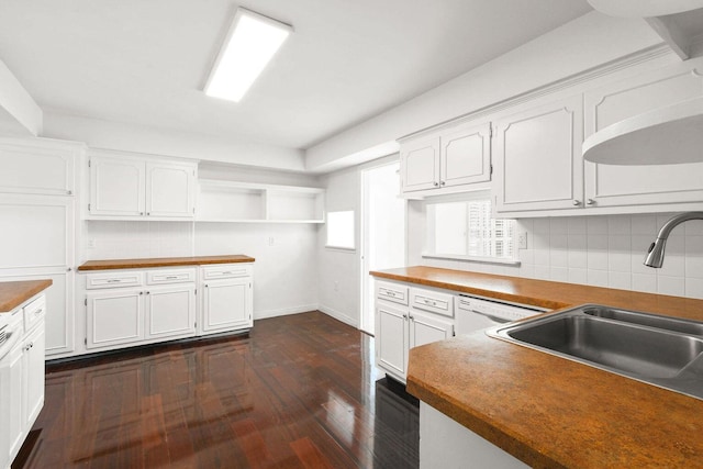 kitchen with butcher block countertops, white cabinets, a sink, and open shelves