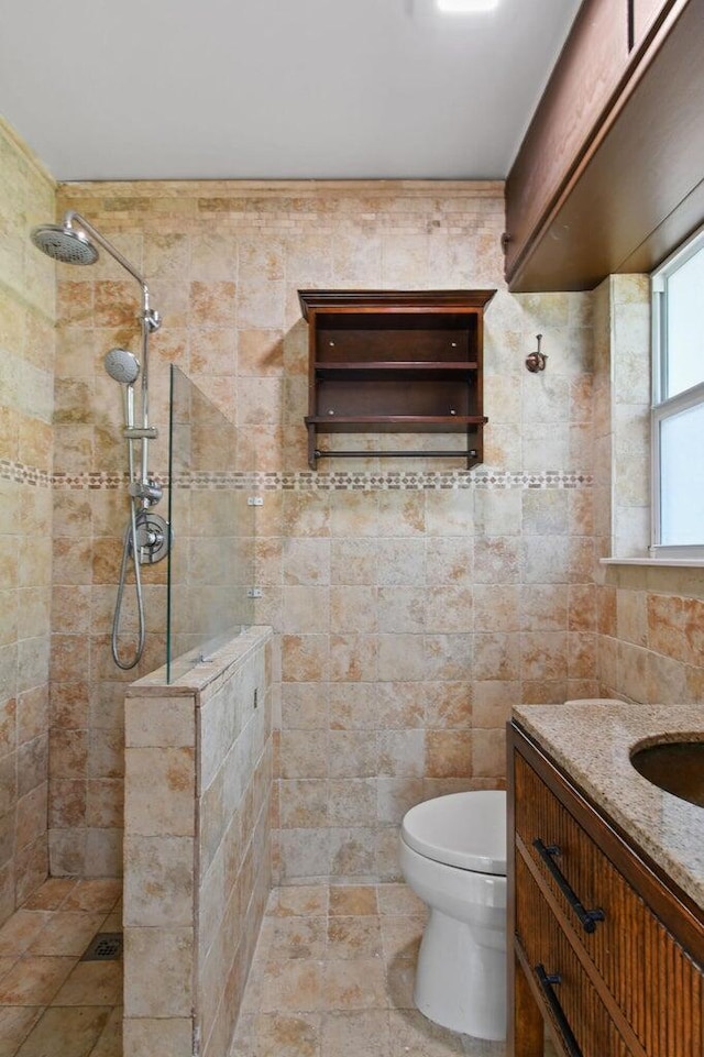 bathroom featuring toilet, walk in shower, vanity, and tile walls