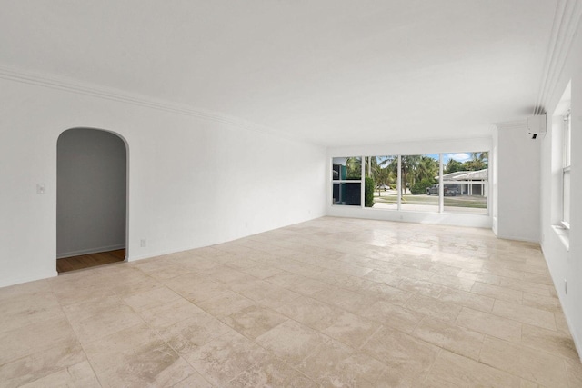 unfurnished room with arched walkways and crown molding