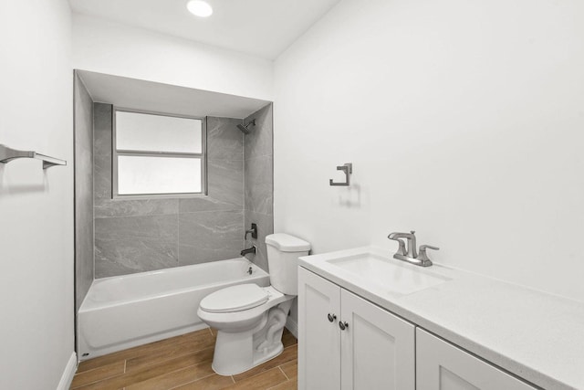 bathroom with bathtub / shower combination, toilet, vanity, baseboards, and wood tiled floor