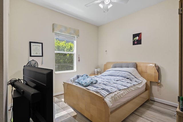 bedroom with baseboards, ceiling fan, and light wood-type flooring