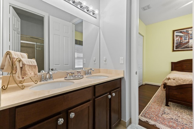 bathroom with double vanity, a sink, a shower stall, and visible vents