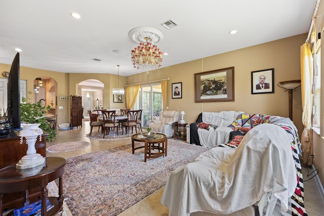 tiled living area with visible vents, a notable chandelier, arched walkways, and recessed lighting