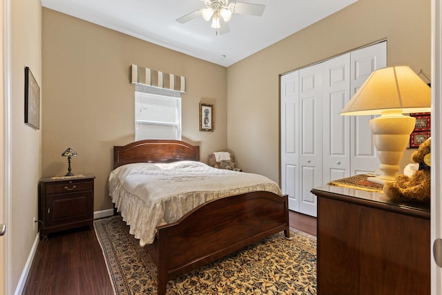 bedroom with a closet, dark wood-style floors, baseboards, and ceiling fan