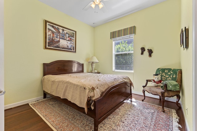 bedroom featuring a ceiling fan, baseboards, and wood finished floors