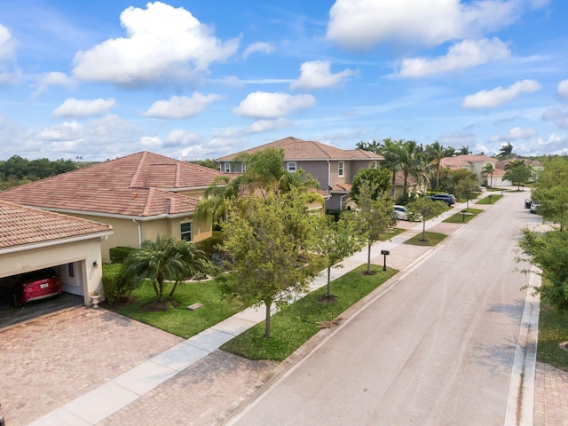 view of front of house featuring a tiled roof, decorative driveway, stucco siding, and an attached garage