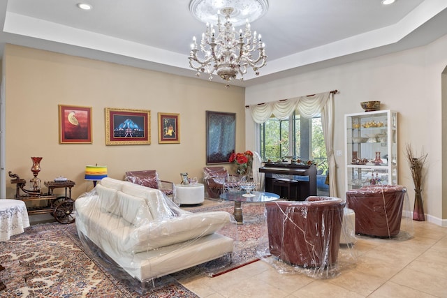 living area featuring tile patterned flooring, a notable chandelier, and a tray ceiling