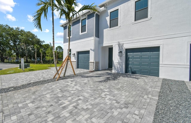 7648 SW Lucy Ln Latitude, Unit Latitude, Stuart, FL 34997 - view of property featuring an attached garage, decorative driveway, and stucco siding
