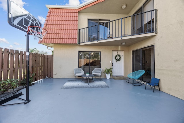 view of patio with a balcony and fence