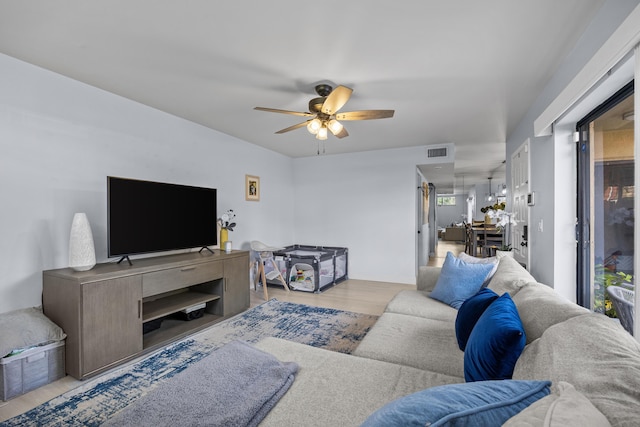 living area featuring light wood-style flooring, a ceiling fan, and visible vents