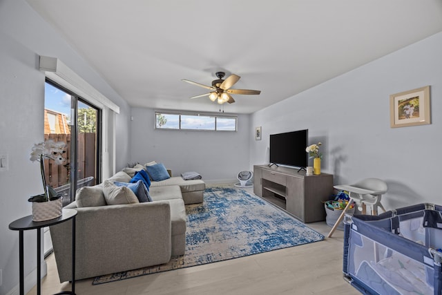 living room featuring wood finished floors, baseboards, and ceiling fan