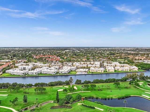 birds eye view of property with golf course view and a water view