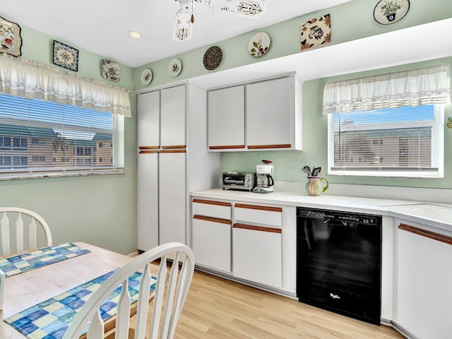 kitchen with dishwasher, light countertops, light wood finished floors, and white cabinetry