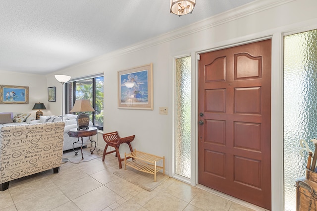 foyer featuring a textured ceiling, light tile patterned flooring, and crown molding