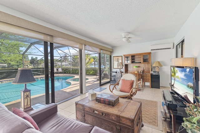 living area featuring ceiling fan, light tile patterned floors, a sunroom, a textured ceiling, and a wall mounted AC