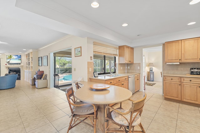 kitchen featuring light tile patterned flooring, a fireplace, ornamental molding, a sink, and light countertops