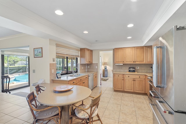 kitchen with light countertops, light tile patterned flooring, crown molding, and stainless steel appliances