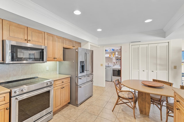 kitchen with washer / clothes dryer, stainless steel appliances, light countertops, crown molding, and backsplash