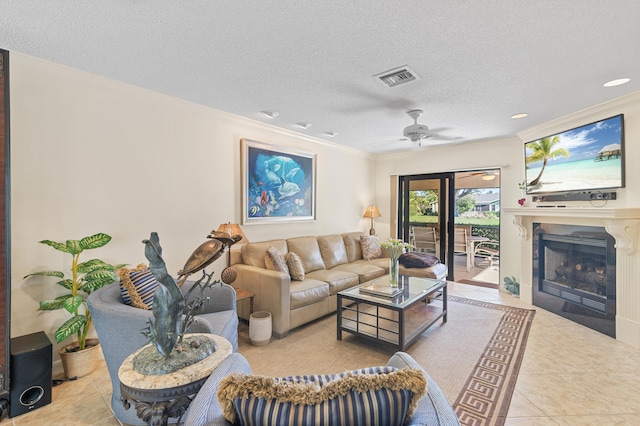 living room with visible vents, a fireplace with flush hearth, ornamental molding, a textured ceiling, and tile patterned floors